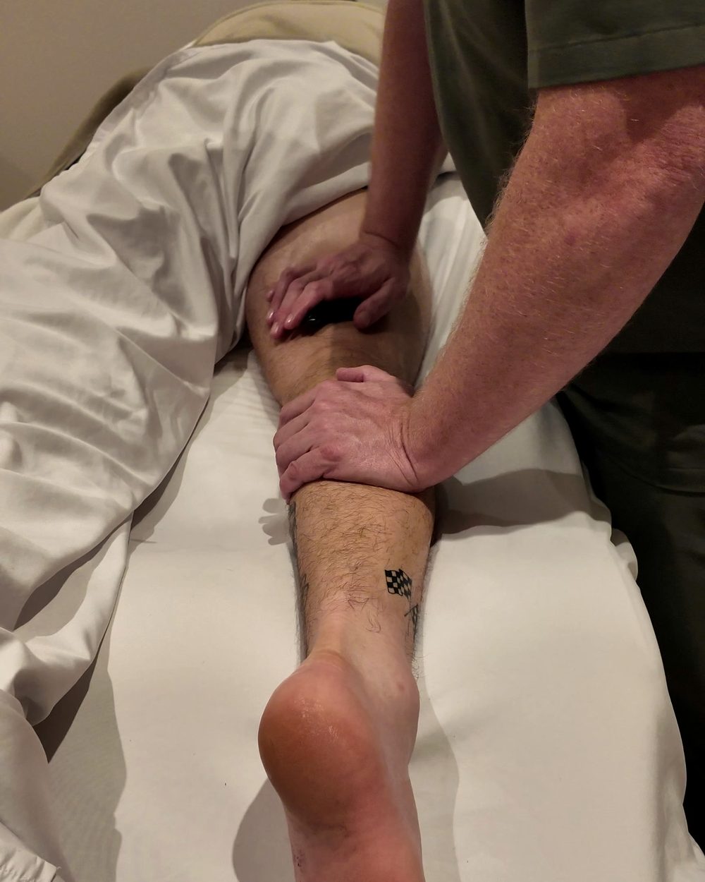 Massage du mollet et de la jambe pendant une séance de kinésithérapie